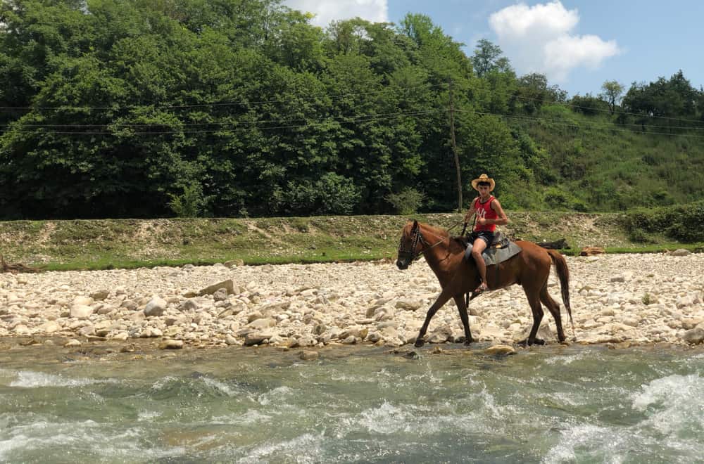 Crossing a stream on a horse
